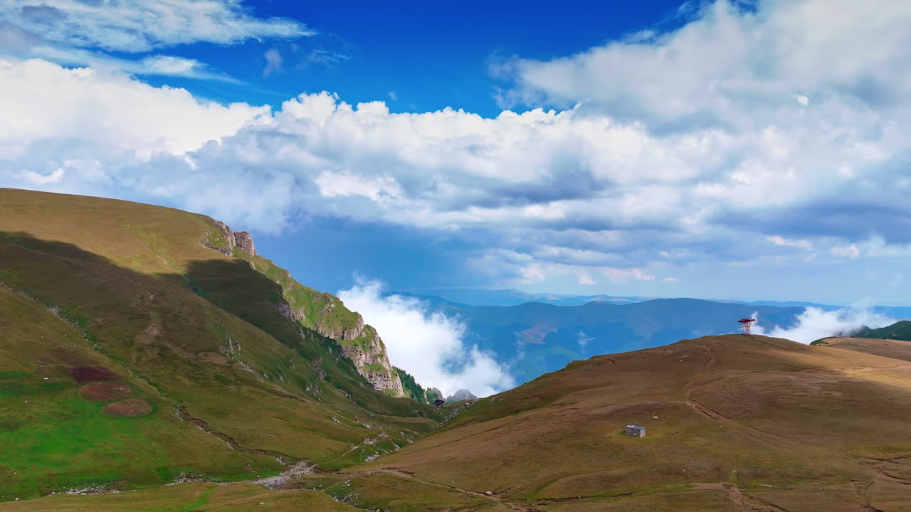 Vast mountain landscape with cloudy sky. Rolling hills meet a vibrant sky filled with clouds and light as nature displays its beauty during the day
