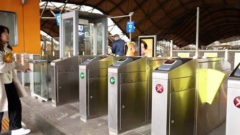 woman uses ticket to pass through turnstile