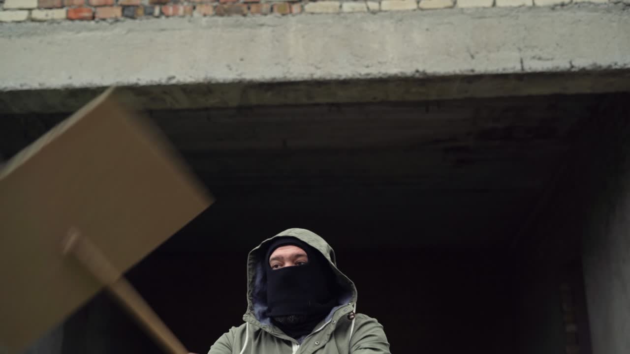 un hombre blanco se pone una balaclava sobre la cabeza, levanta un cartel y comienza una protesta. copia puntos de seguimiento de espacio. tablero de pantalla verde en blanco.