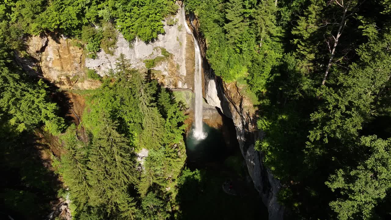 Vista aerea della cascata Berglistüber, dove il torrente Fätschbach emerge da una grotta naturale ricoperta di muschio a Glarus Süd, in Svizzera. La potente cascata si getta sulle scogliere scoscese