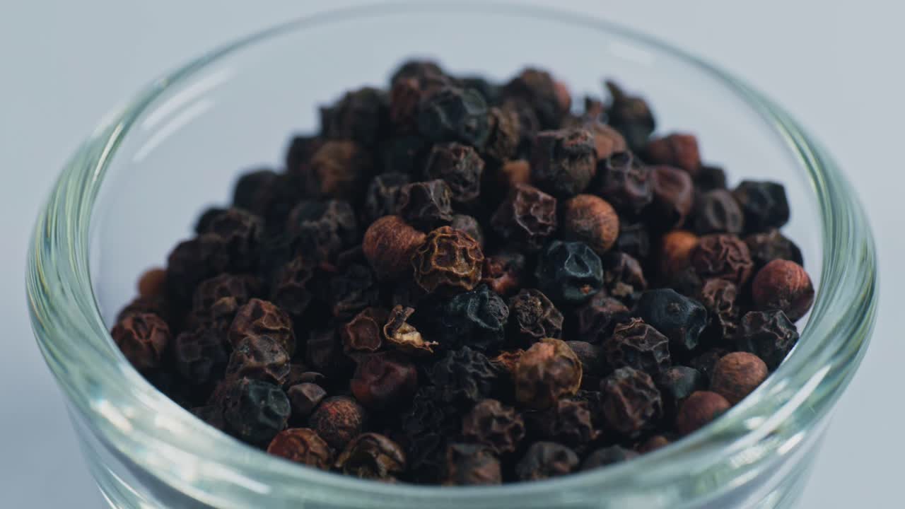 Black pepper or kali mirch in small glass bowl, 4k, parallax shot.