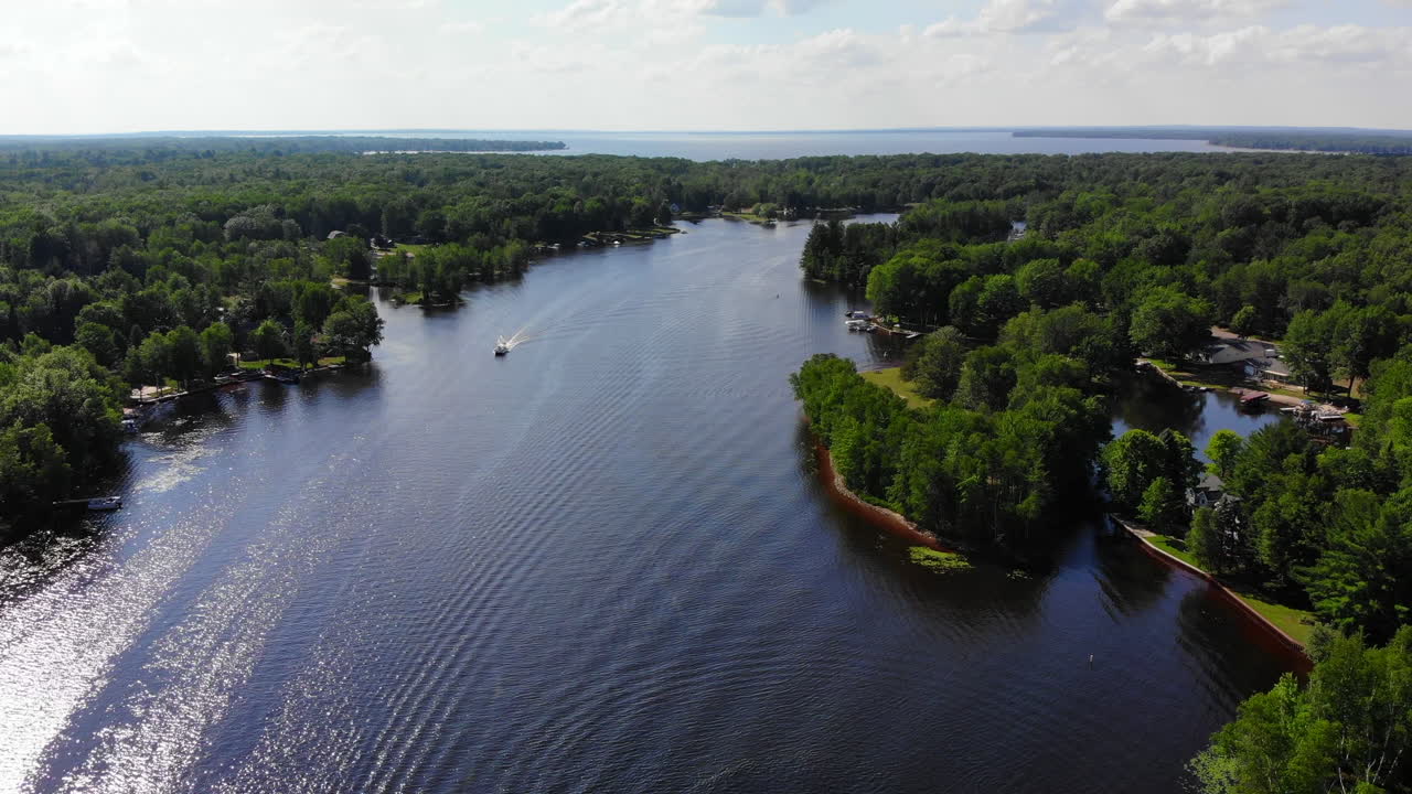 Ripresa aerea di imbarcazioni e attività ricreative su un piccolo lago nel Michigan settentrionale, USA, in estate.