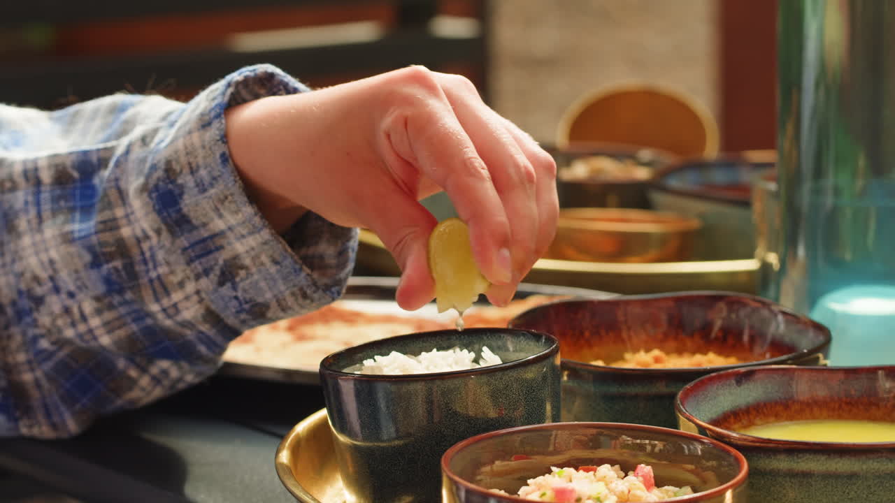 Person squeezing lime over rice at a meal