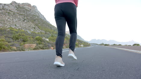 jogging on mountain road, woman wearing athletic shoes and leggings