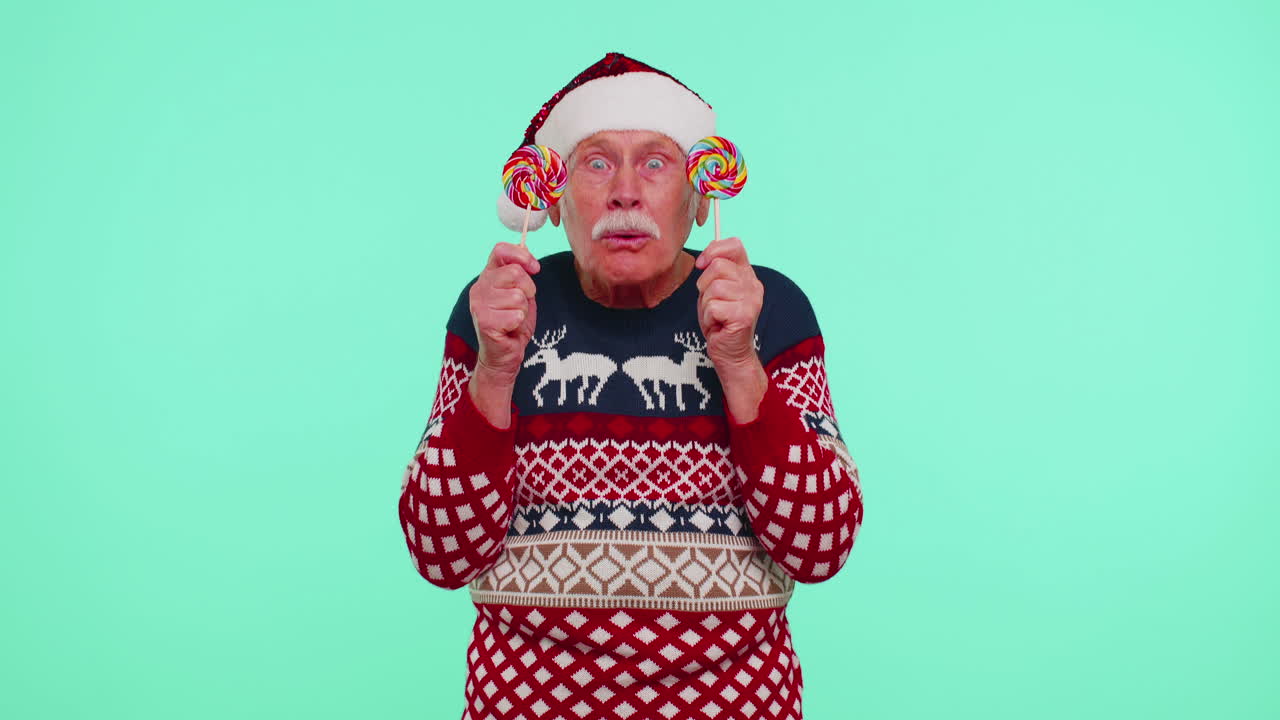 크리스마스 스웨터를 입은 할아버지가 사탕 줄무 릴리을 들고 그들 뒤에 숨어서 장난을 치고 있습니다.