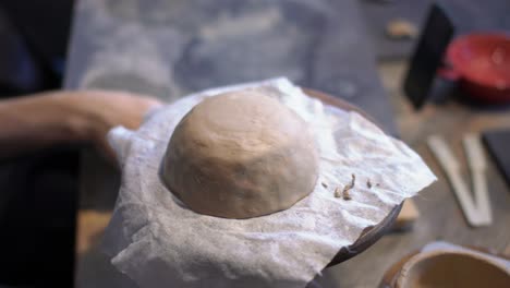 female hands crafting with modeling clay in an artisan studio during a ceramic class