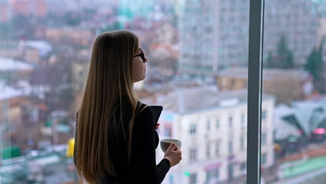 beautiful woman wearing eyeglasses using cellphone and drinking coffee