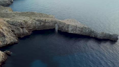 hermoso arco de roca natural, pont d'en gil en menorca, españa - aéreo de lado