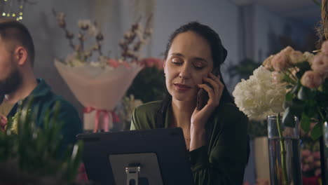 Female-Florist-Talks-By-Phone-with-Customer-and-Uses-Tablet