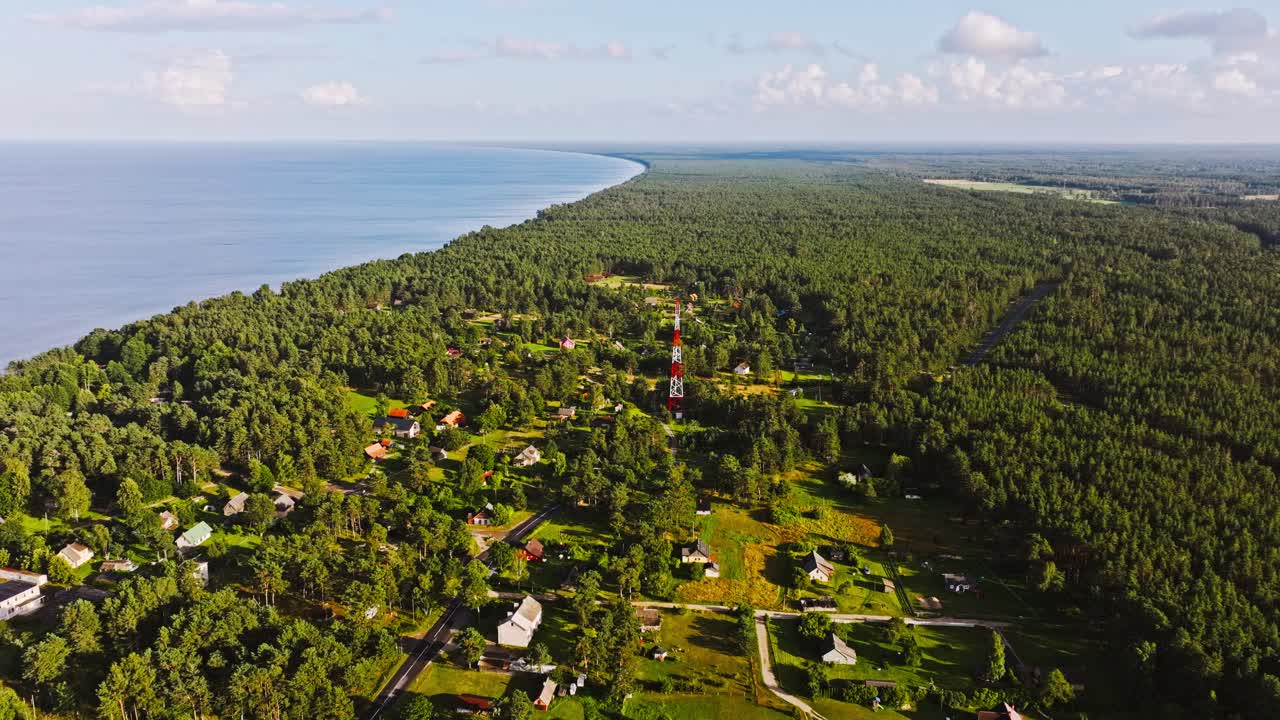 Aerial cinematic view Melnsils Latvia settlement by forest and Baltic Sea shore