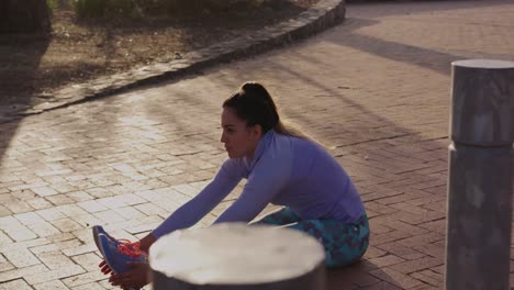mujer caucásica estirándose en un parque