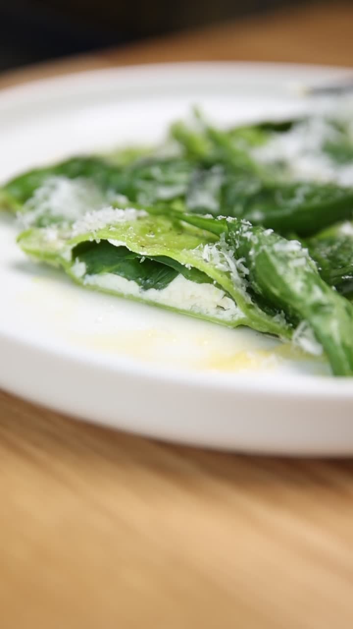 Primo piano di ravioli di pasta verde con formaggio e Parmigiano