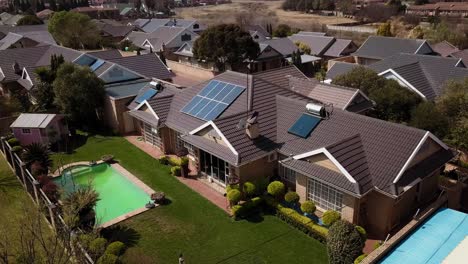 aerial view of a residential area with solar panels and swimming pools