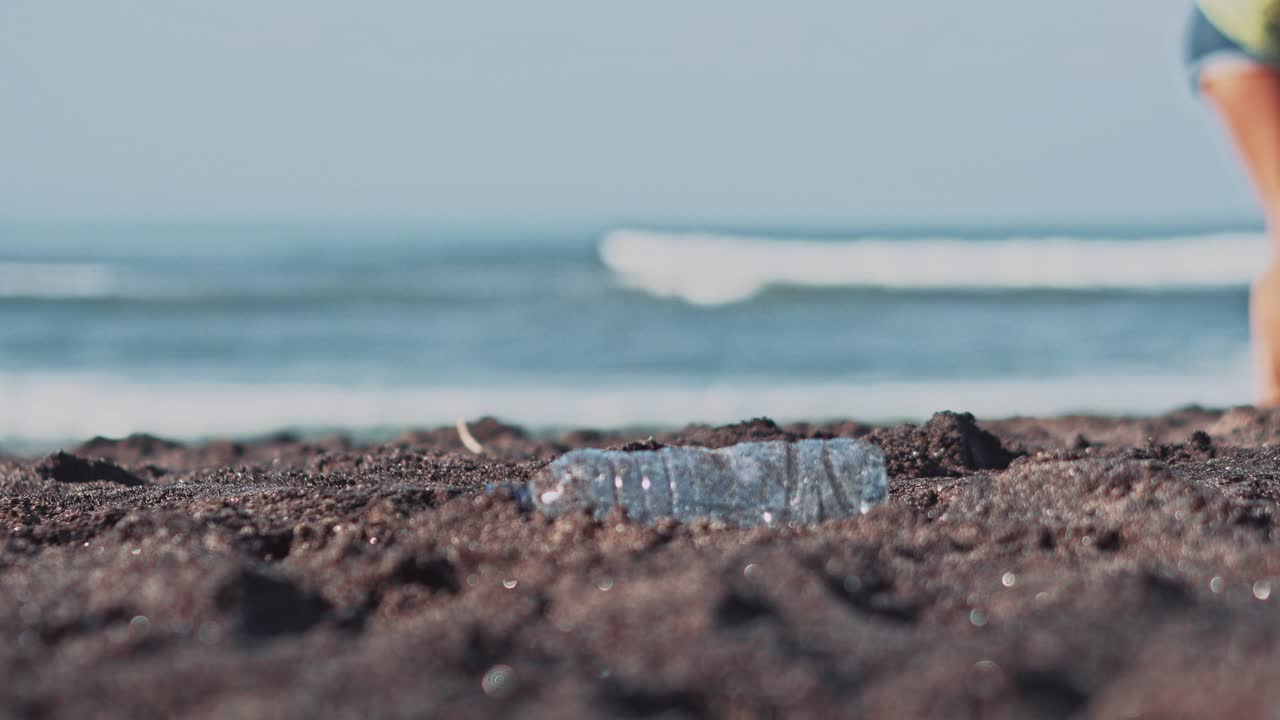 자원봉사자 그룹이 해변을 청소합니다. 자원봉사는 플라스틱 병을 들고 가방에 던집니다. 자원 봉사 및 재활용 개념. 환경 인식 개념. 복사 공간.