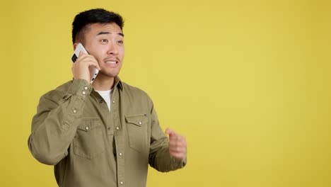 excited asian man celebrates good news on a phone call