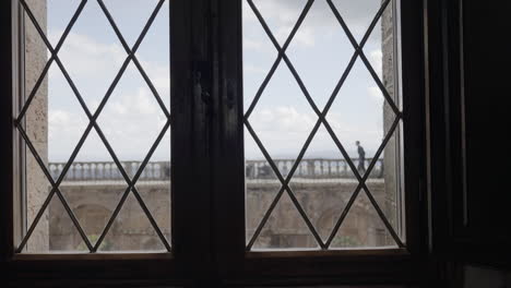 window view of people walking on a balcony