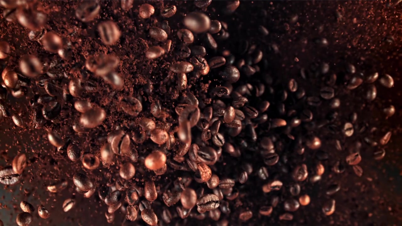 Chicchi di caffè tostati e caffè macinato che cadono al rallentatore estremo