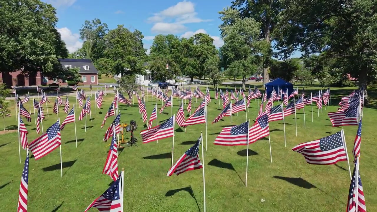 American Flags Set Up On A Lawn To Honor Veterans. - aerial shot