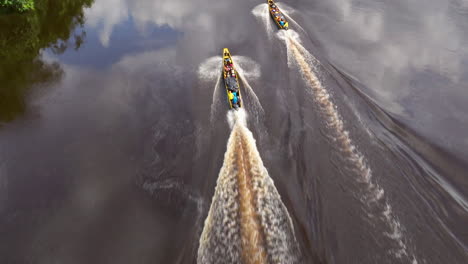 longboats carrying people on a tropical river