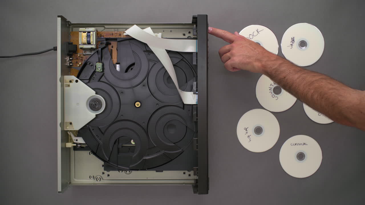 Hand Chooses Mixtape Among CDs to Play, Top Down