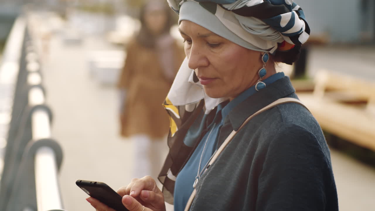 mujer madura usando un teléfono inteligente al aire libre