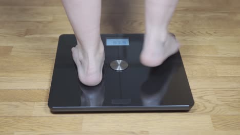 person weighing themselves on a digital scale