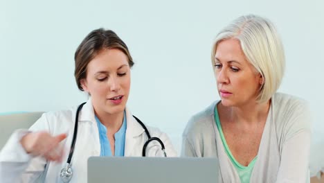 Female-doctor-interacting-over-a-x-ray-report-with-a-patient