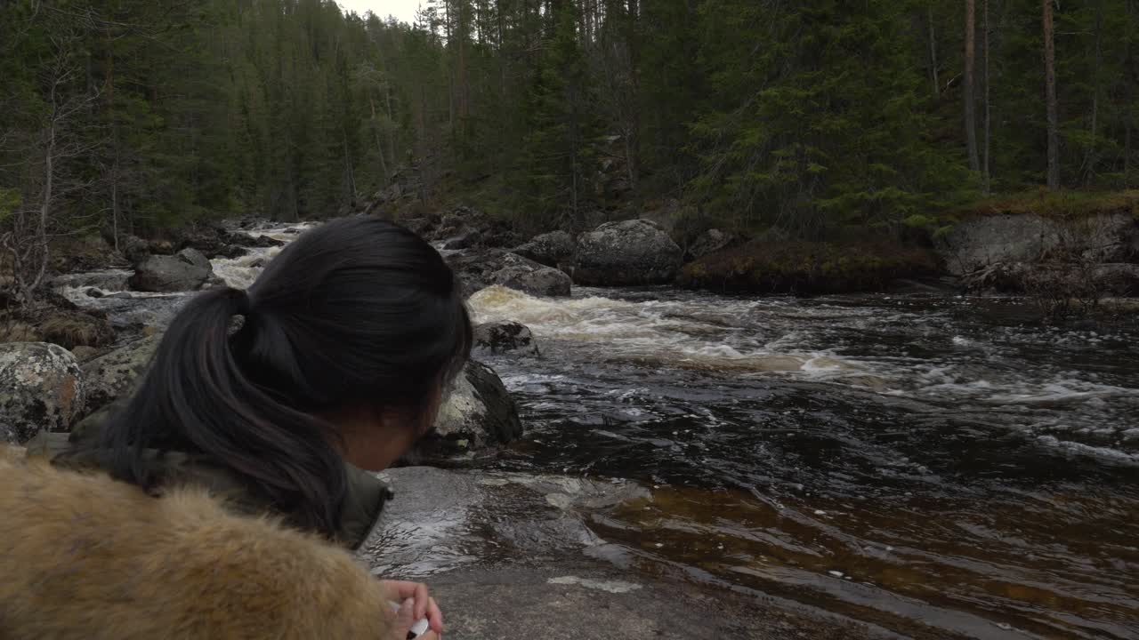 소녀는 숲의 상처가 많은 강가에 앉아 있다