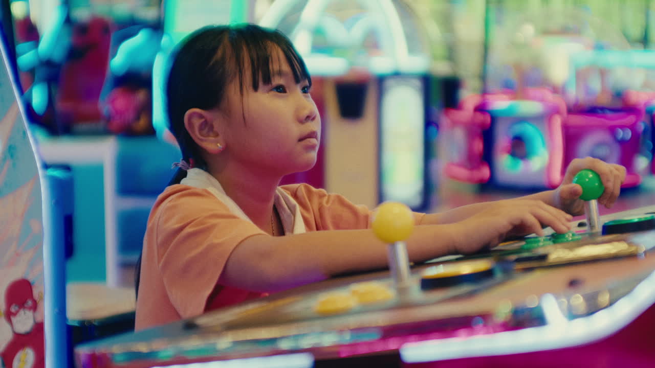 ritratto di una ragazzina che gioca a videogiochi nella sala giochi arcade del parco divertimenti concentrarsi sul controller mentre gioca una partita