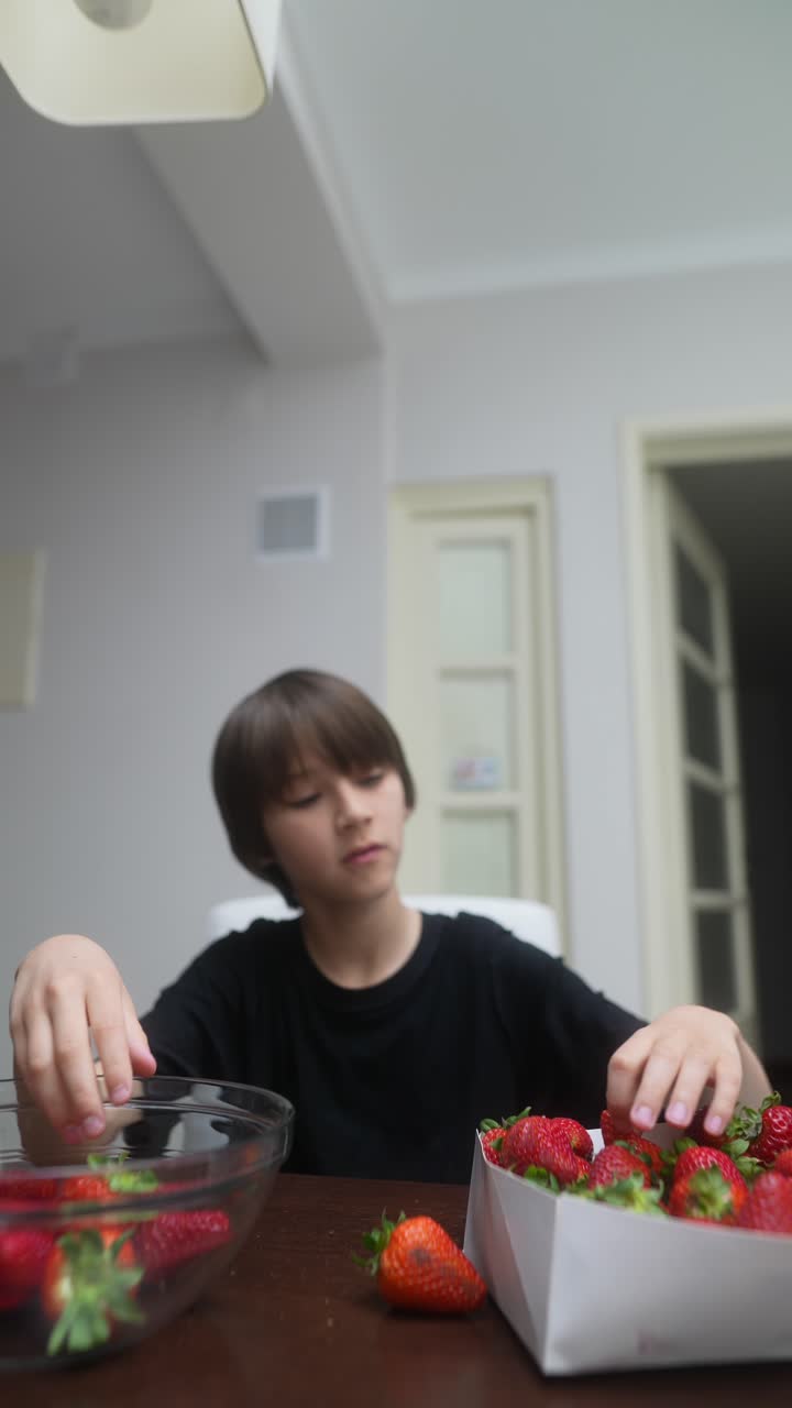 Boy eating strawberries at home