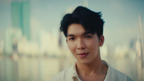 young American asaitic male portrait holding flower bouquet cityscape in background