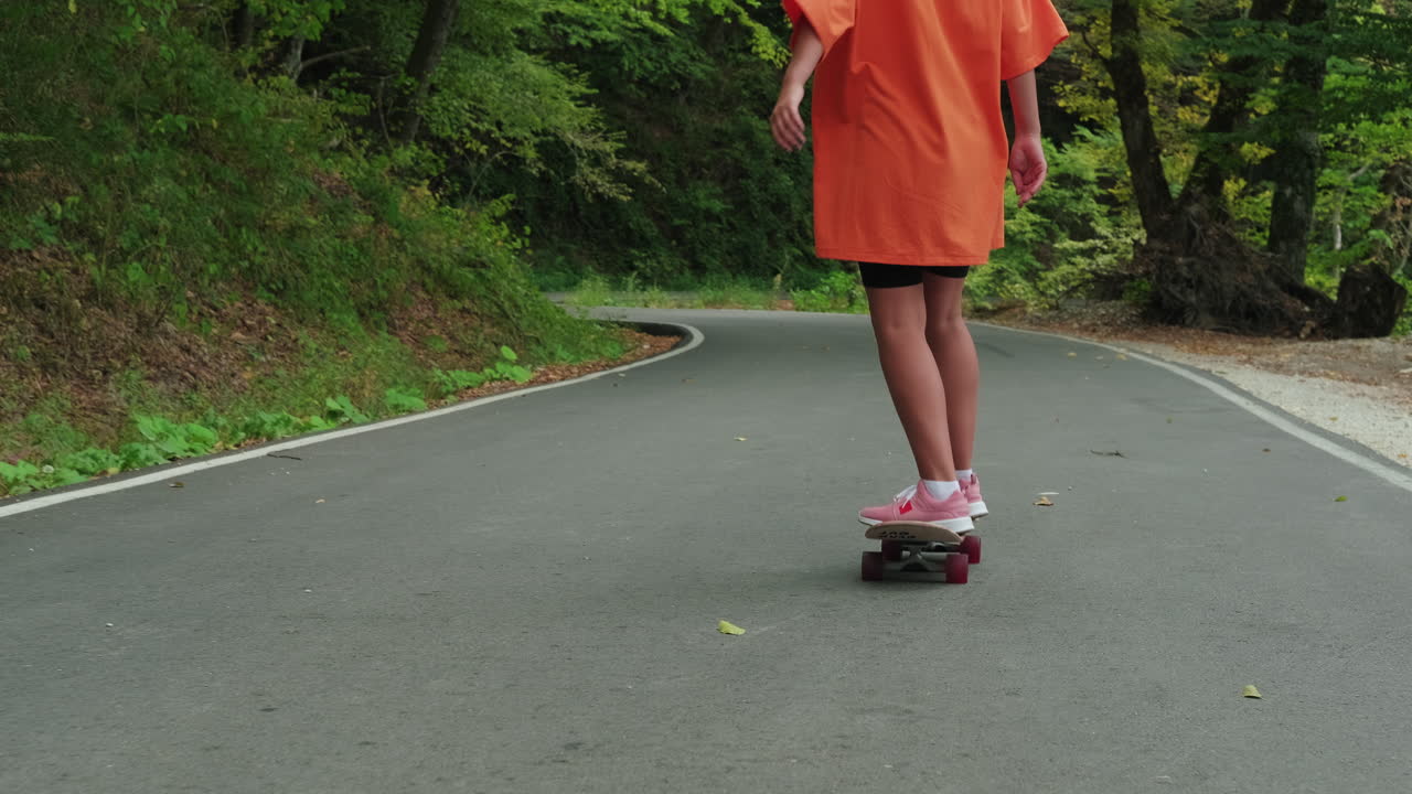 mujer patinando en un camino del bosque