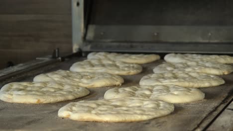 the baker prepares the ramadan pita dough to go into the oven