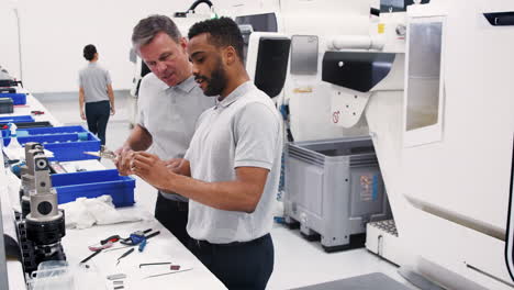 ingenieur und männlicher lehrling messkomponenten in einer hightech-ingenieurfabrik