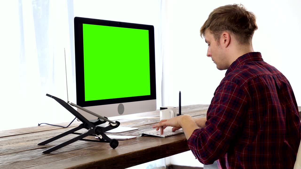 The freelancer programmer typing with green screen display