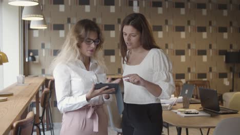 colegas mujeres discutiendo el proyecto usando una tableta