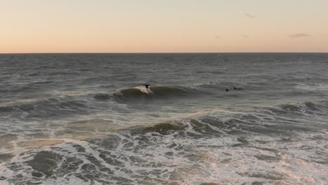 surfers in front of the touristic town domburg in the netherlands during sunset