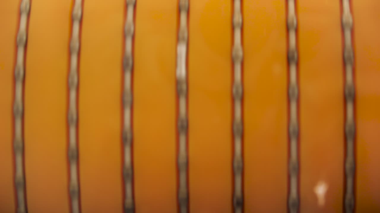 objeto cilíndrico naranja con patrón vertical