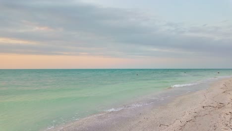 clear turquoise water meeting the shoreline of holbox's punta cocos, mexico at dusk