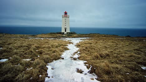 Una-Toma-Cinematográfica-Aérea-En-4k-Muestra-Un-Imponente-Faro-En-Islandia,-Rodeado-De-Vastos-Paisajes-Abiertos.