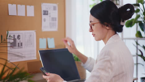 Self-Confident-Businesswoman-Working-on-Laptop-and-Smartphone