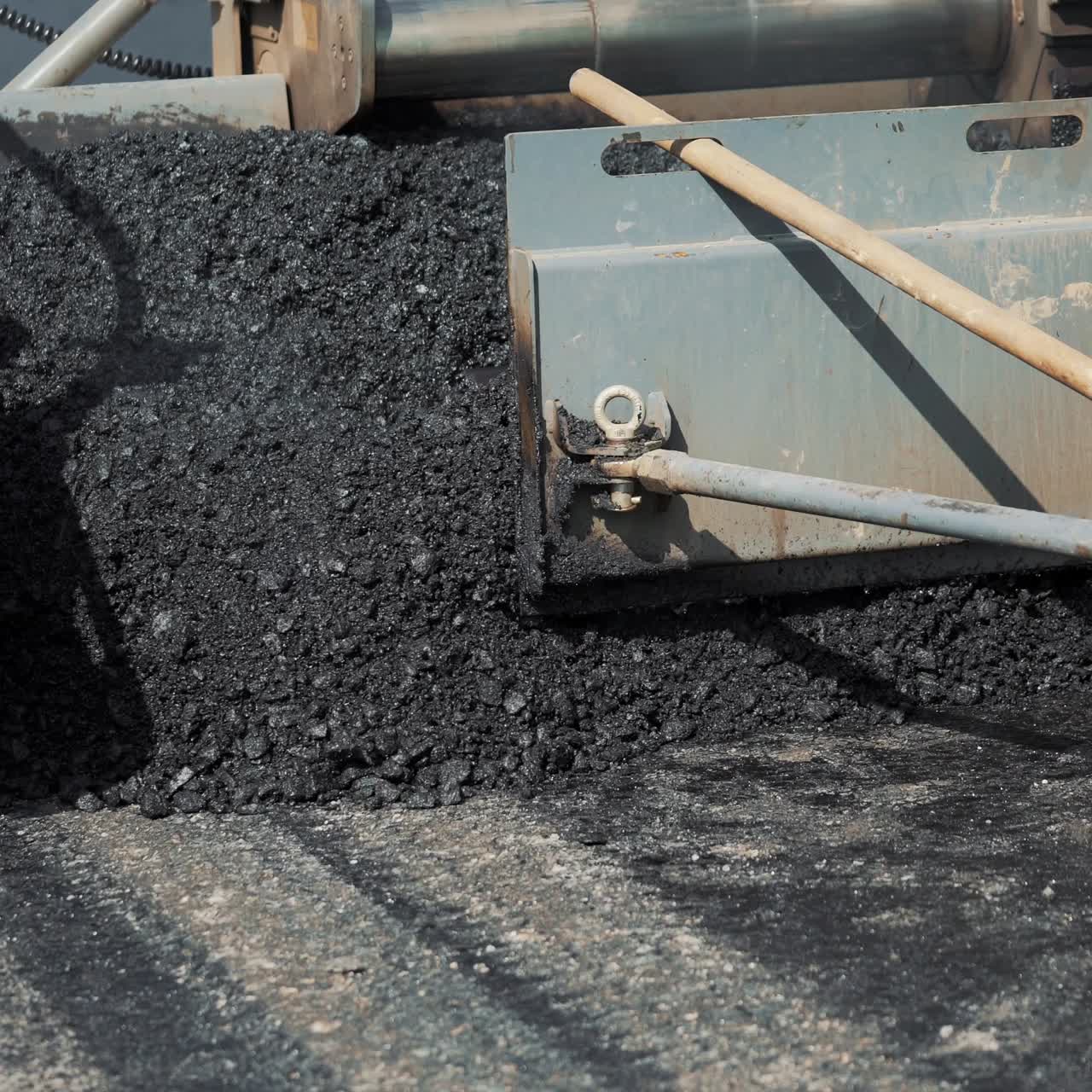 professional equipment is filling with bitumen and smoothing it on the road for packing asphalt. Modern road repair technology