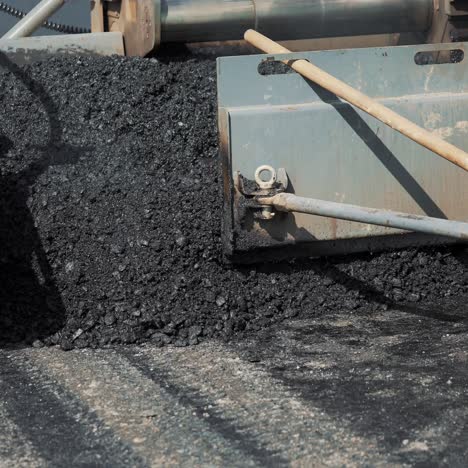 professional equipment is filling with bitumen and smoothing it on the road for packing asphalt. modern road repair technology