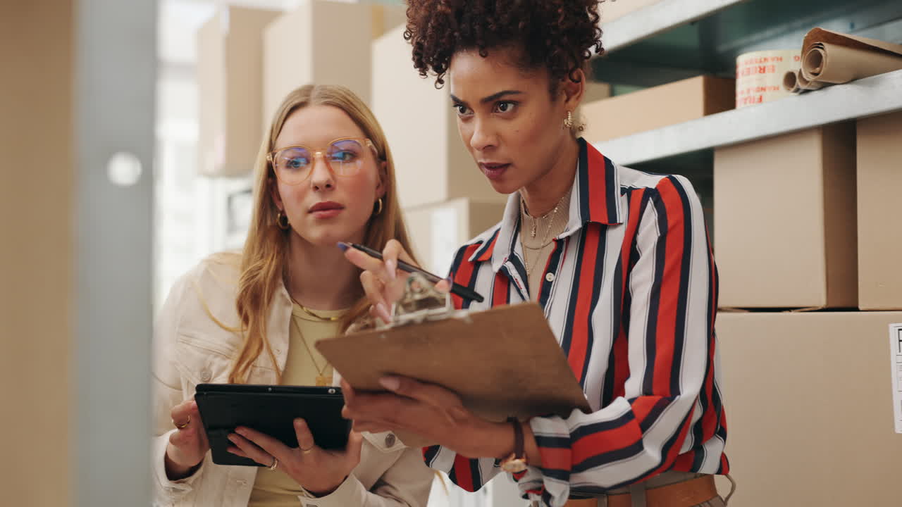 Women managing inventory in a warehouse with tablet and clipboard
