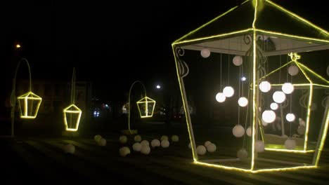 Outdoor-Christmas-decorations-at-night,-artistic-lanterns-and-big-flashing-light-balls,-wide-shot