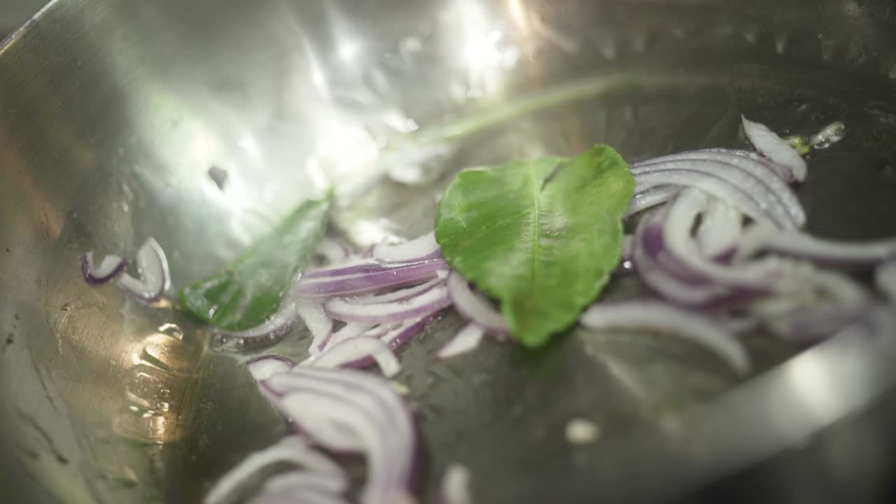 Cooking Onions and Kaffir Lime Leaves in a Pan