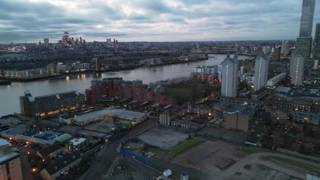 Londoner-City-Skyline-In-Der-Abenddämmerung-In-Der-Nähe-Von-Canary-Wharf,-Großbritannien,-Drohnen-Luftaufnahme