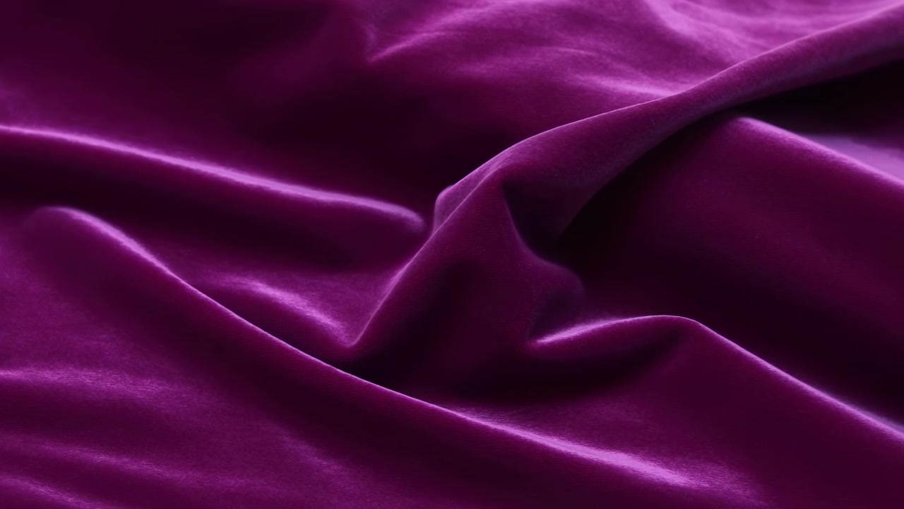 Tela de terciopelo morado drapeada en pliegues suaves, ambiente de boutique de lujo con brillo satinado y destellos.