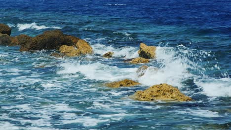 waves breaking on rocks on a sunny day