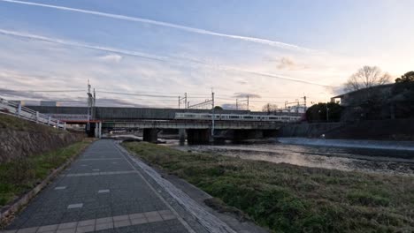 time-lapse of a train crossing a bridge at sunset